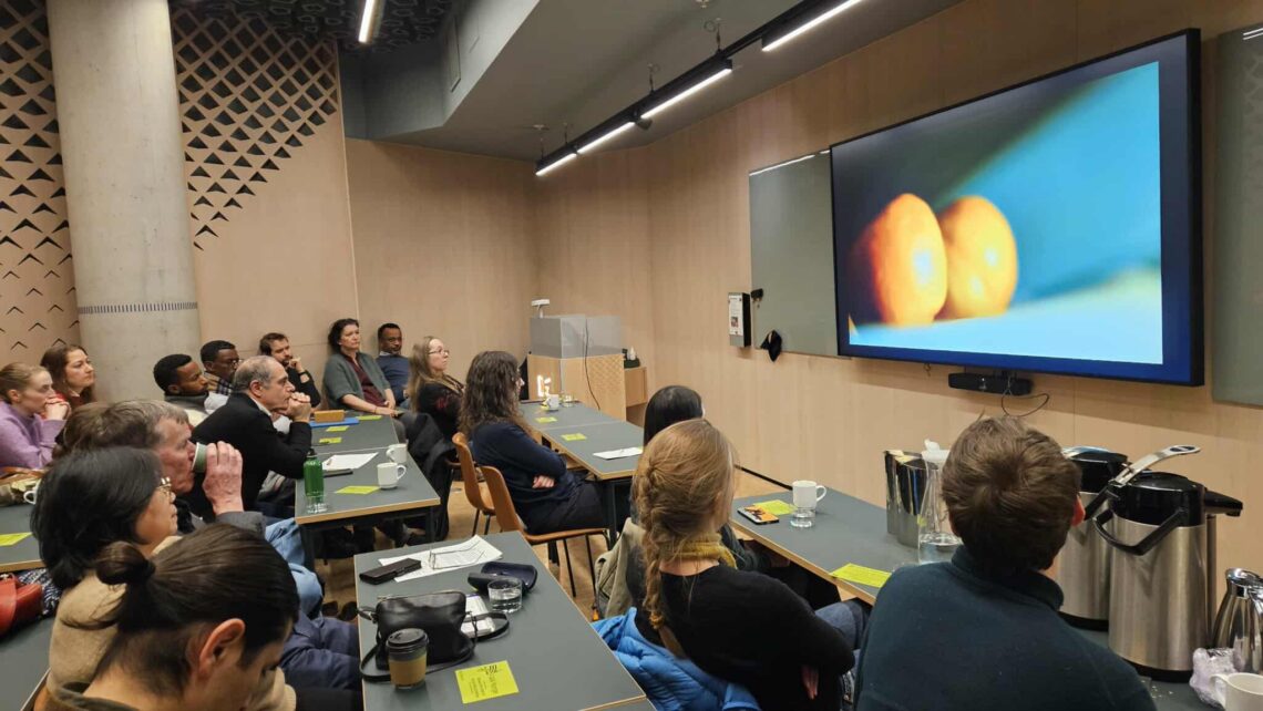 Bildet viser ernæringskafe med Norsk forening for ernæringsvitenskap og FIAN. Bildet viser et møterom fylt med mennesker som ser på filmen The Pickers.